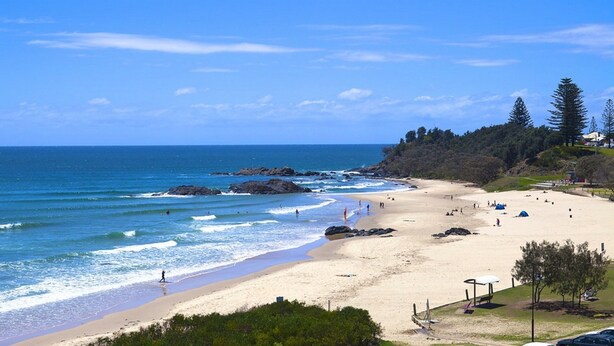 A beach with clear skies, rocky outcrops, and a few people. - Flynns Beach Resort (Port Macquarie)