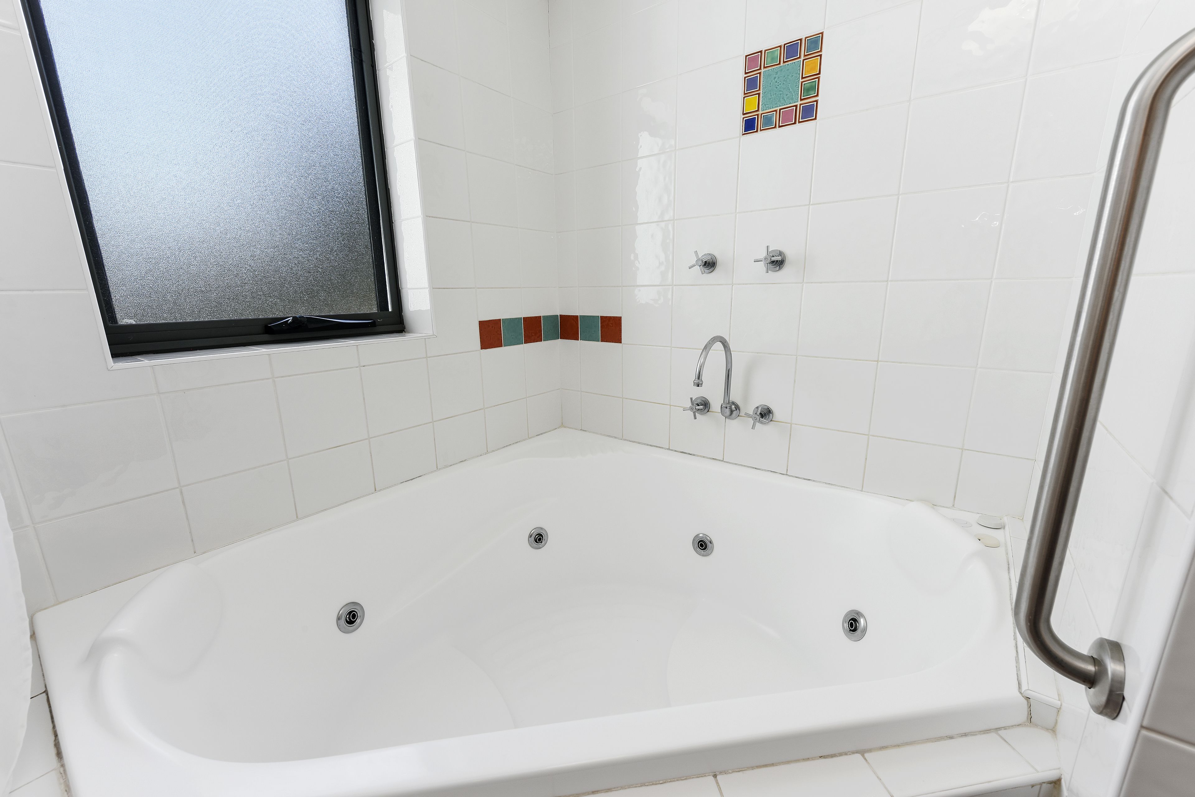 Une salle de bain moderne avec une baignoire sur pieds, une fenêtre et un espace douche.