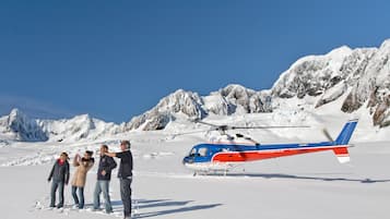A helicopter with the text "HELICOPTER UNEC" parked on snow.