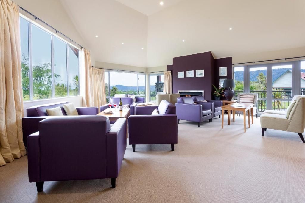 A spacious living room with large windows, a fireplace, and a view of the outdoors.