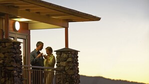 A stone balcony with a railing, overlooking a landscape with hills. - Te Weheka Hotel Fox Glacier  (Fox Glacier)