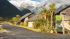 A mountain lodge with a signboard indicating 'Glenfern Villas' and 'Inspection Welcome'.