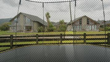 Un espace clos, doté d’un terrain de basketball, entouré de bâtiments et d’un champ d’herbe.