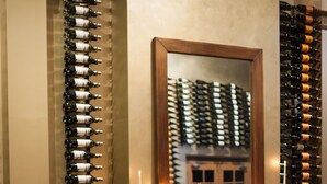 A restaurant with a fireplace, candles, and a wine rack.