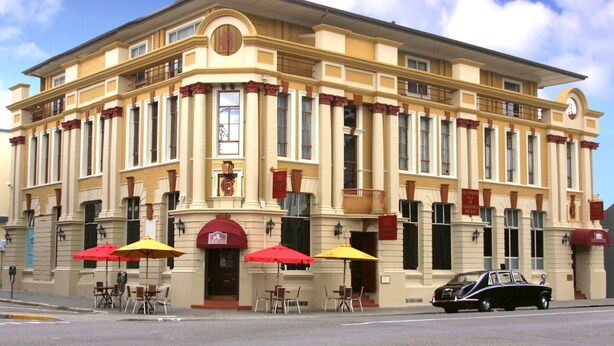 A historic building with a symmetrical facade, large windows, and a central entrance.