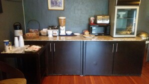 A kitchen with dark cabinets, a microwave, a toaster, and a blender on the countertop. - Sonora Gold Lodge (Sonora)