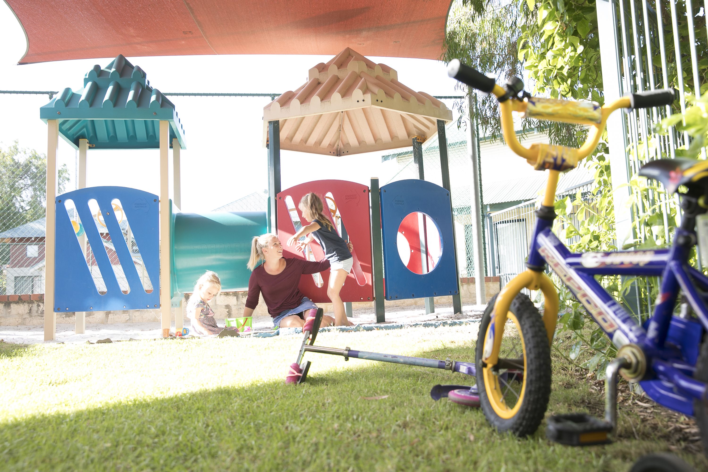 Ein Spielplatz mit Klettergerüst, überdachter Sitzgelegenheit und einem Fahrrad.