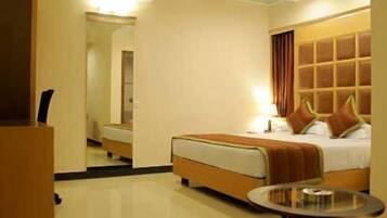 A hotel room with a bed, bedside table, and a mirror.