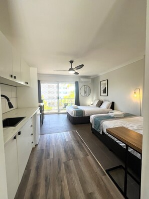 Cortinas blackout, tabla de planchar con plancha y ropa de cama 