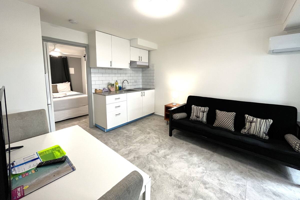 A compact living space with a kitchenette, a dining area, and a sofa.