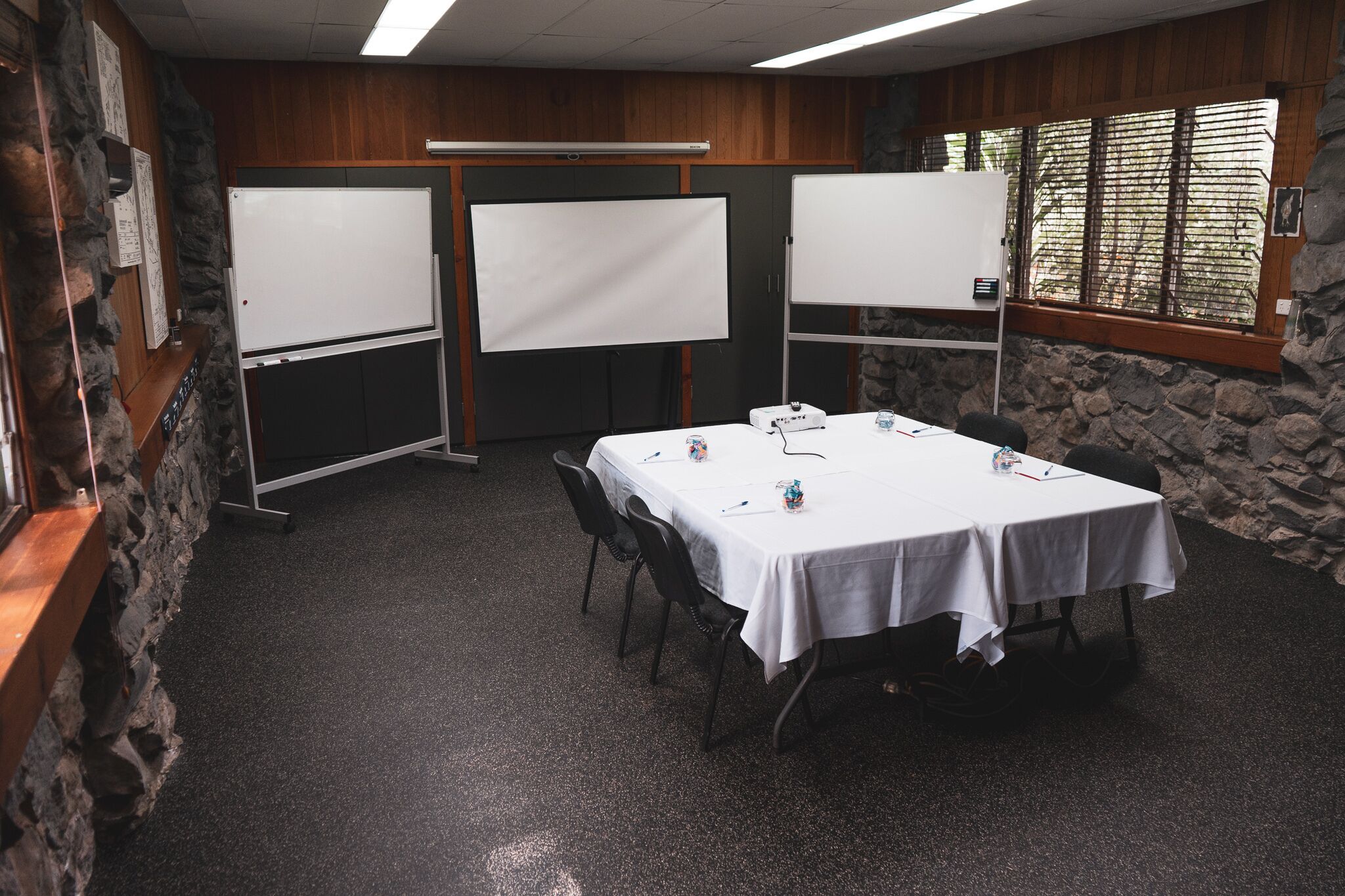 A conference room with a white table, chairs, and two whiteboards.
