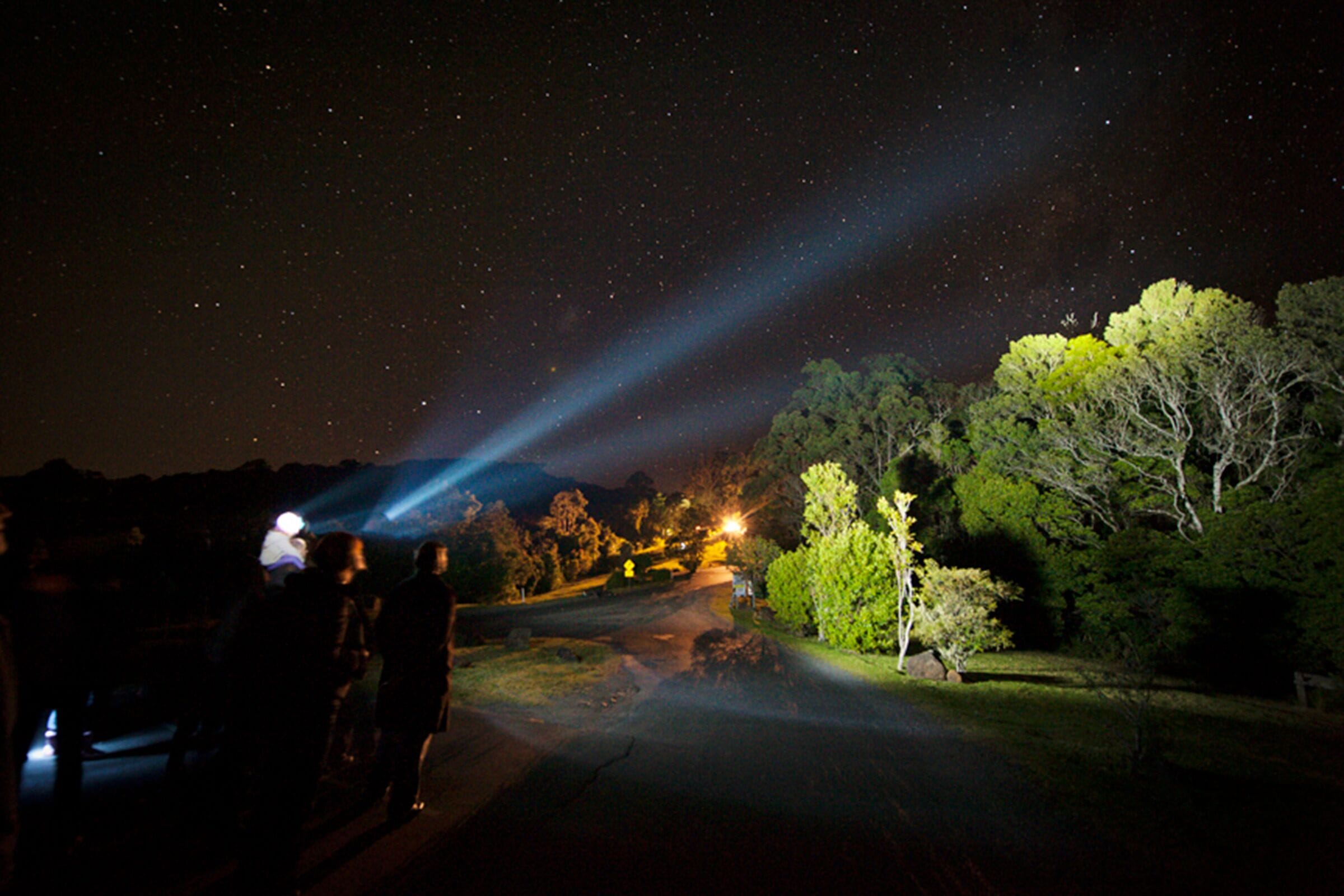 A starry night sky with a beam of light from a telescope.