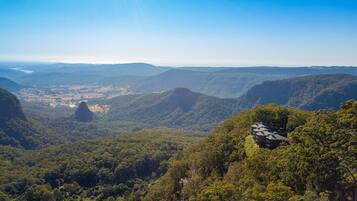 Escape to a serene mountain retreat with breathtaking views of the surrounding forested hills and valleys.