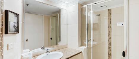Une salle de bain moderne avec un lavabo, un miroir et une douche à parois en verre.