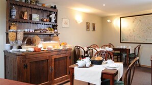 A dining area with a wooden buffet, chairs, and a table set for a meal. - Hotel Albert I (Bruges)