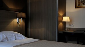 A hotel room with a bed, a desk, and a lamp. - Hotel Albert I (Bruges)