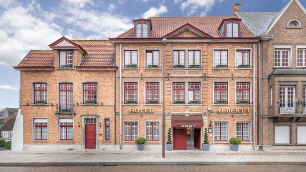 A multi-story hotel with a classic brick facade, red doors, and multiple windows. - Hotel Albert I (Bruges)