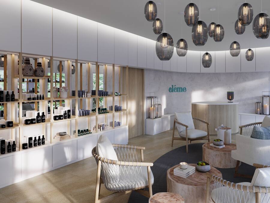 A modern interior with a central seating area, a display of products on shelves, and hanging spherical light fixtures.