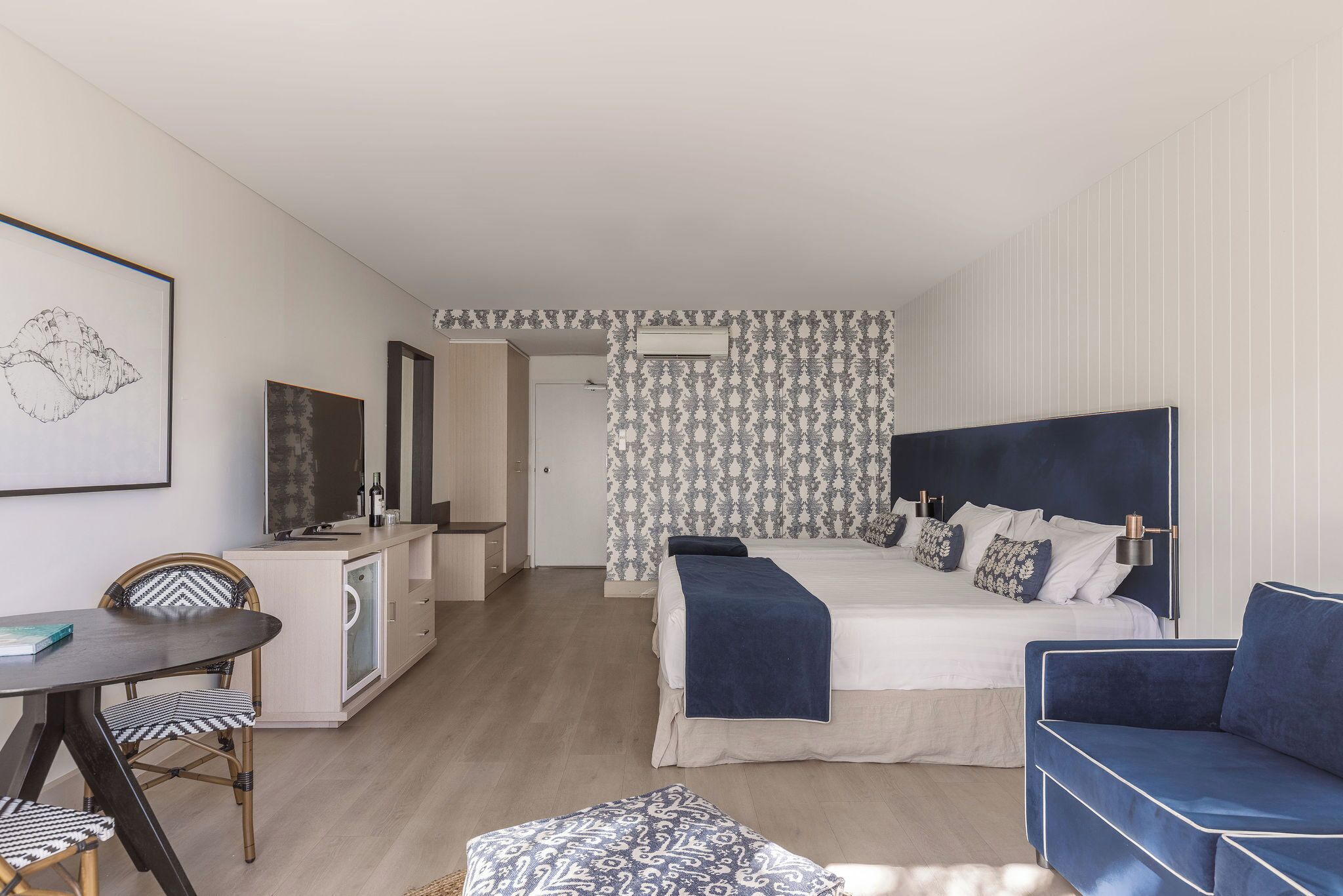Un dormitorio moderno con cama, mesitas de noche, escritorio y silla.