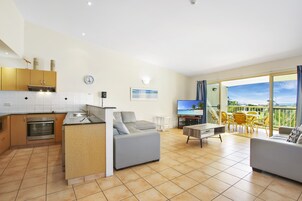 A modern apartment with a kitchen, living area, and balcony.