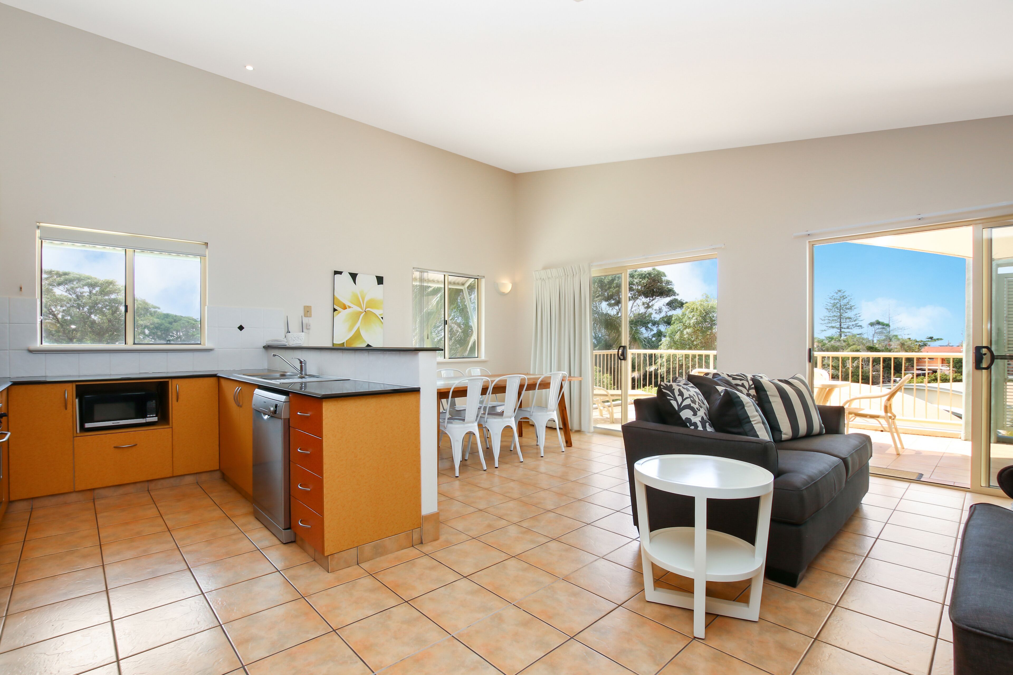 A spacious living area with a kitchen, dining area, and balcony.