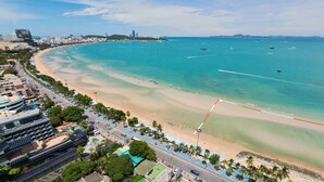 A coastal cityscape with a wide beach, clear blue waters, and modern buildings along the shore. - Holiday Inn Pattaya by IHG (Pattaya)