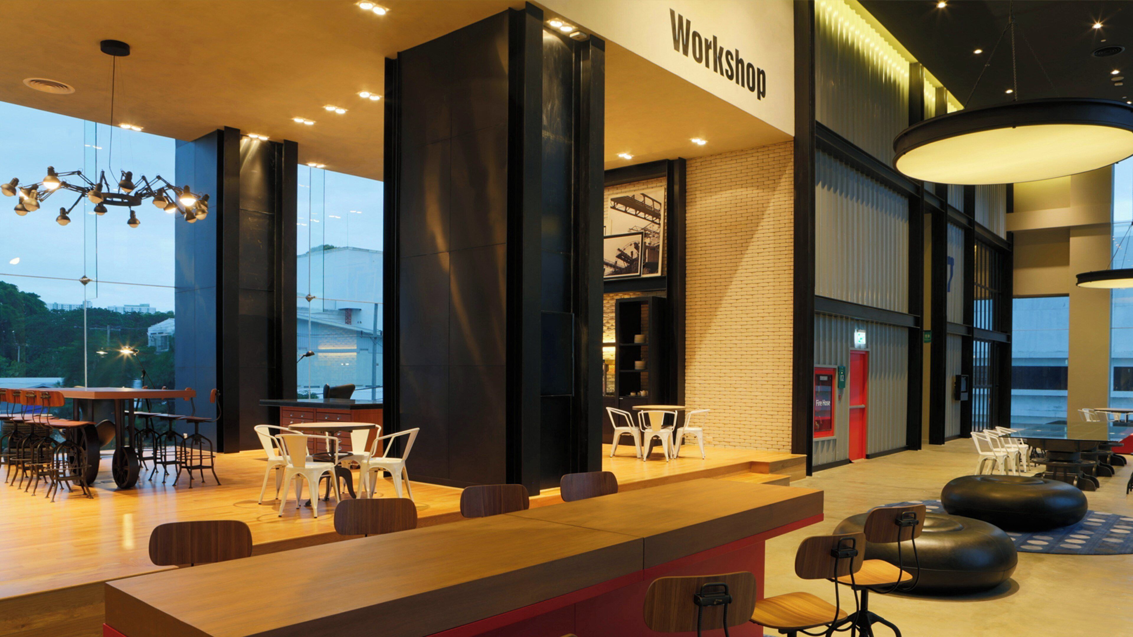 A modern interior with a reception desk, seating area, and a view of the outside.