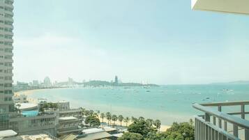 A coastal cityscape with a view of the sea, buildings, and a clear sky.