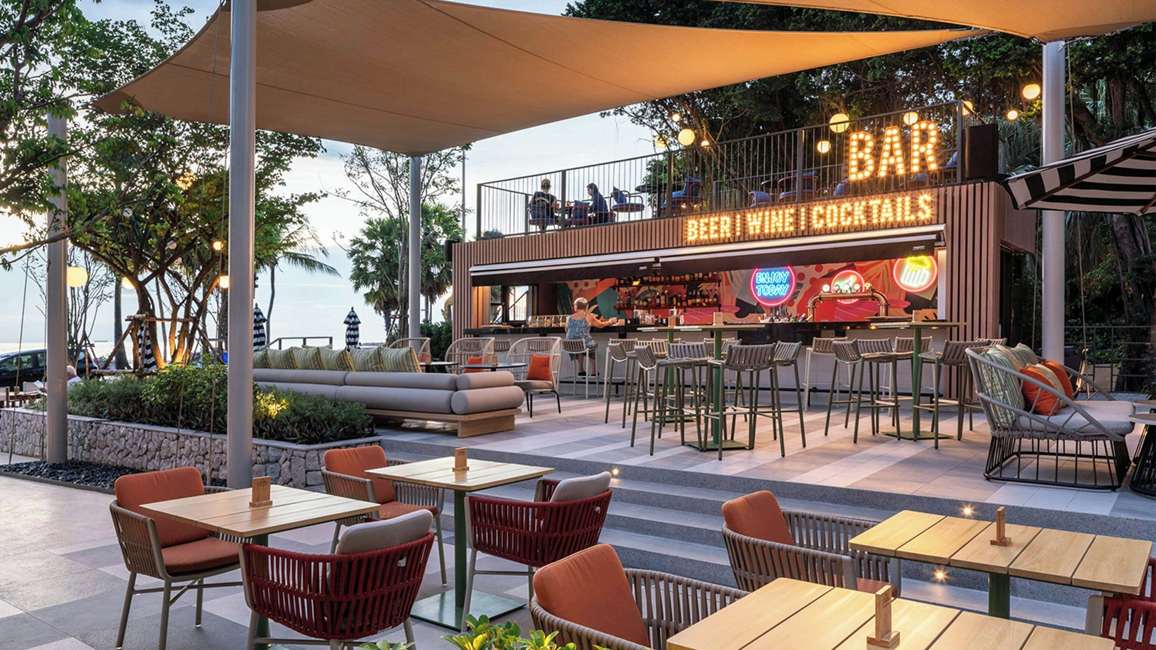 An outdoor bar area with seating and a view of the ocean.