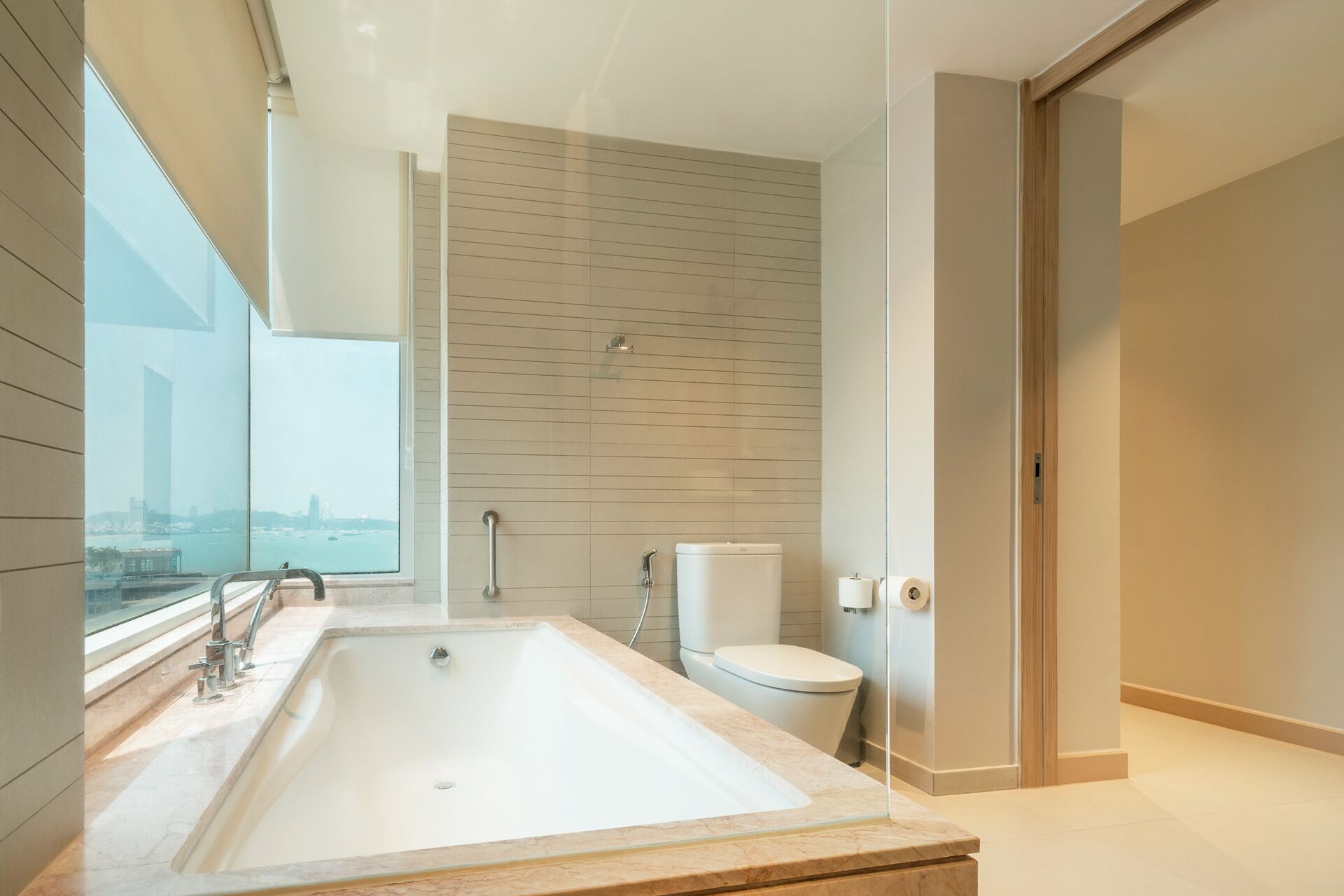 A modern bathroom with a large bathtub, a toilet, and a shower area.