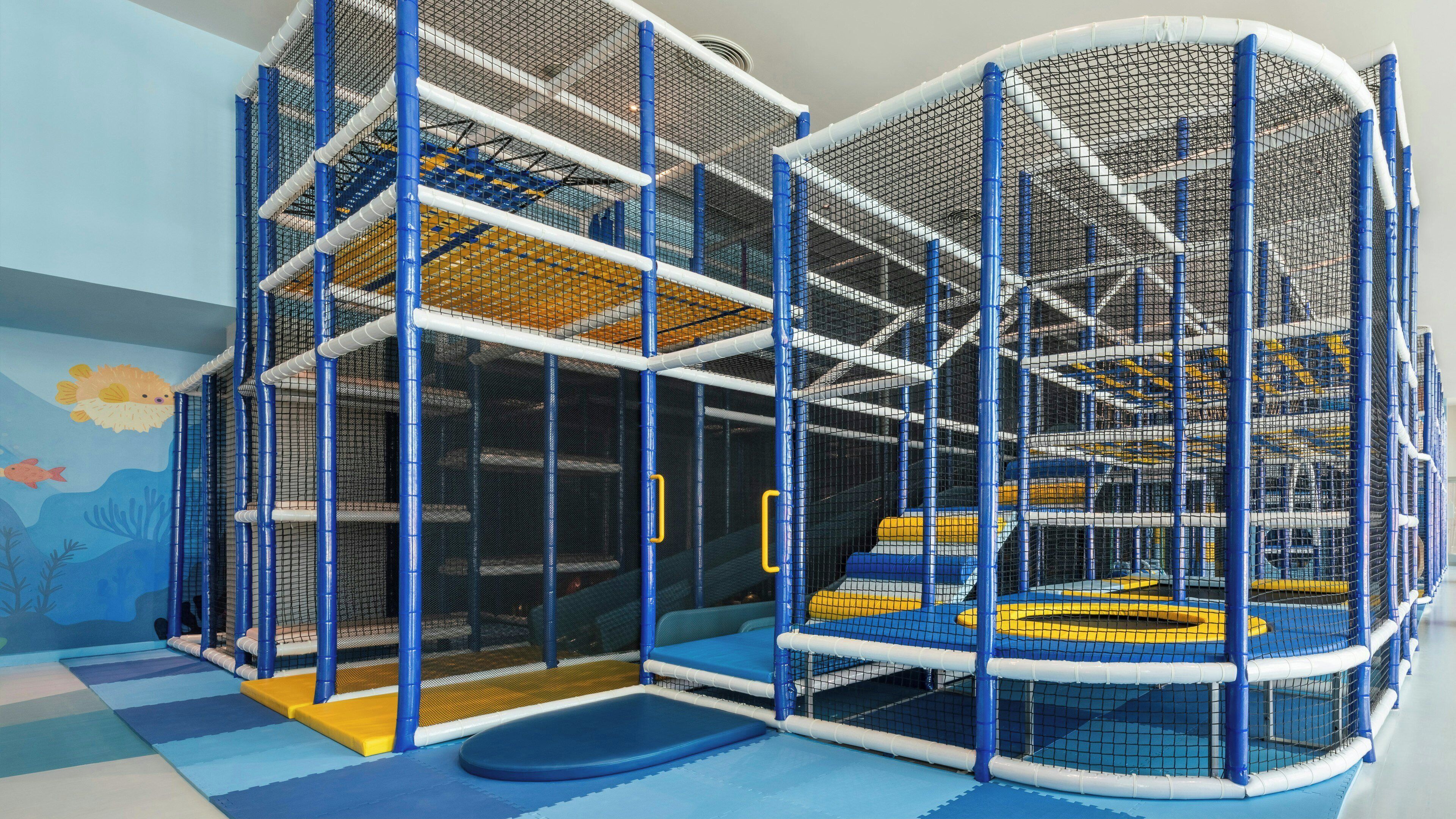 A multi-level play structure with netted walls and various platforms.