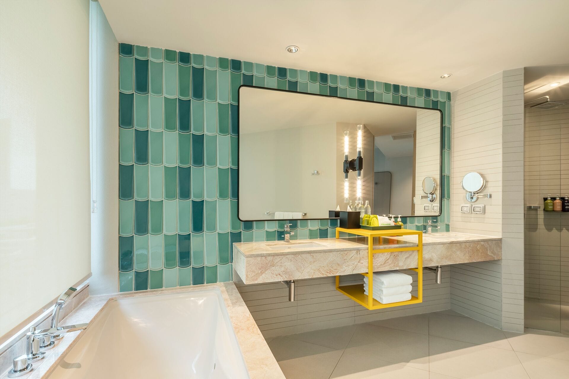 A modern bathroom with a large bathtub, a vanity with a mirror, and a shower area.