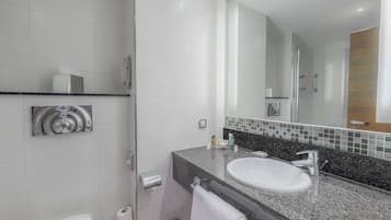 A modern bathroom with a white toilet, a sink with a mirror above it, and a towel rack.