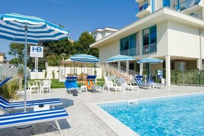 Piscine extérieure, parasols de plage, chaises longues