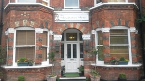 Ein Backsteinhaus mit einem Schild, auf dem "The Wimbledon Hotel" steht.