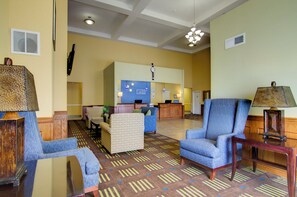 A hotel lobby with a reception desk, seating area, and a patterned carpet. - Holiday Inn Express Hotel & Stes Kansas City Sports Complex by IHG (Kansas City)