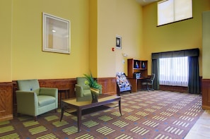 A hotel lobby with a reception desk, seating area, and a large window with curtains. - Holiday Inn Express Hotel & Stes Kansas City Sports Complex by IHG (Kansas City)