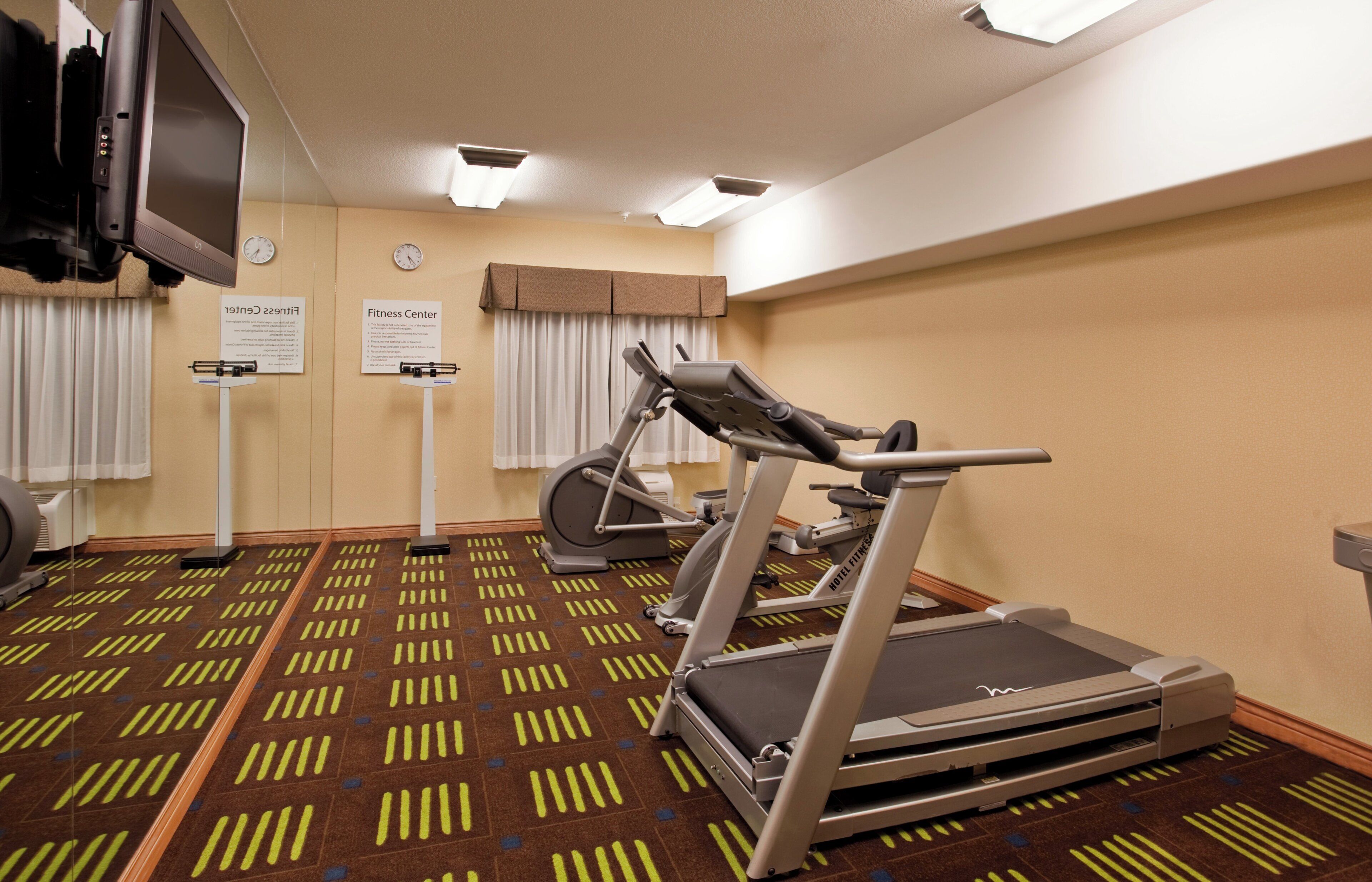 A hotel fitness center with treadmills, an elliptical, and a stationary bike.