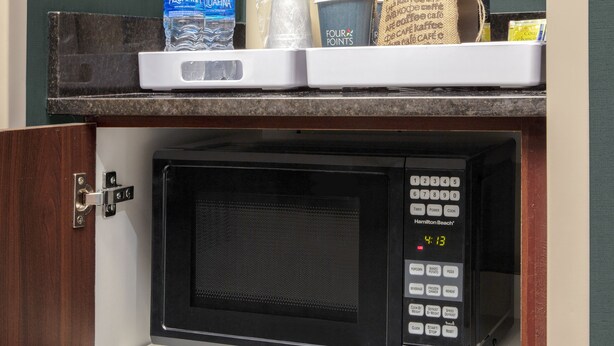A kitchen area with a microwave, a coffee machine, and a water dispenser on the counter. - Four Points by Sheraton Fort Lauderdale Airport - Dania Beach (Dania Beach)