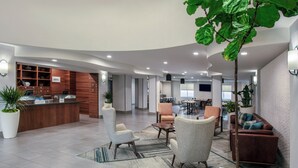 A modern lobby with a reception desk, seating area, and a dining space. - Four Points by Sheraton Fort Lauderdale Airport - Dania Beach (Dania Beach)