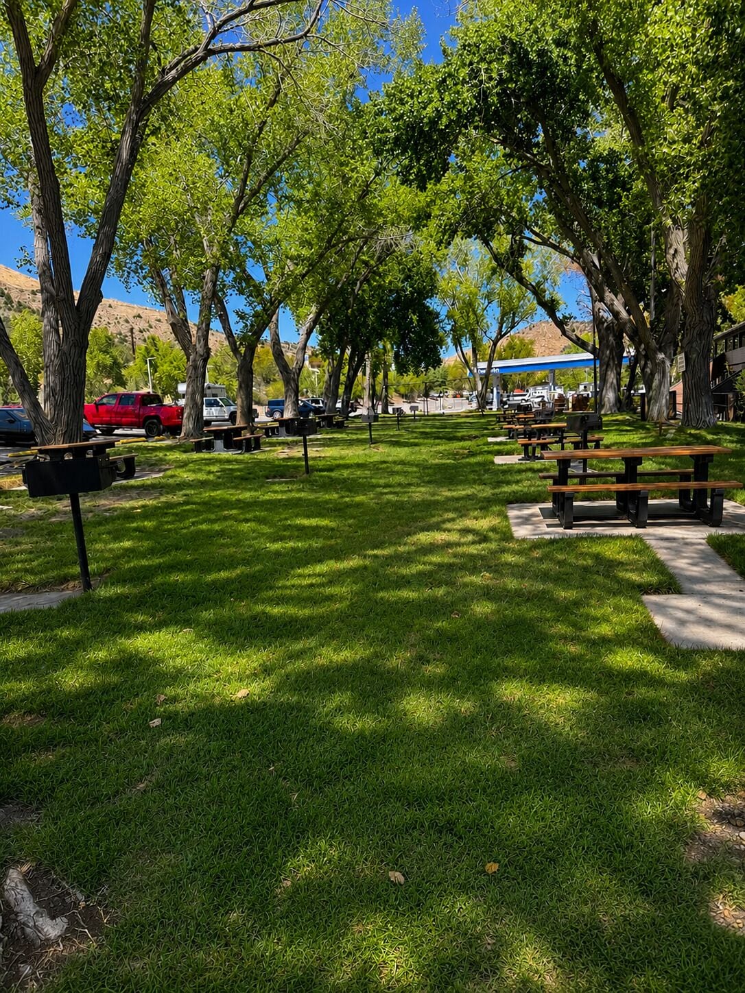 A park with picnic tables and a barbecue area.