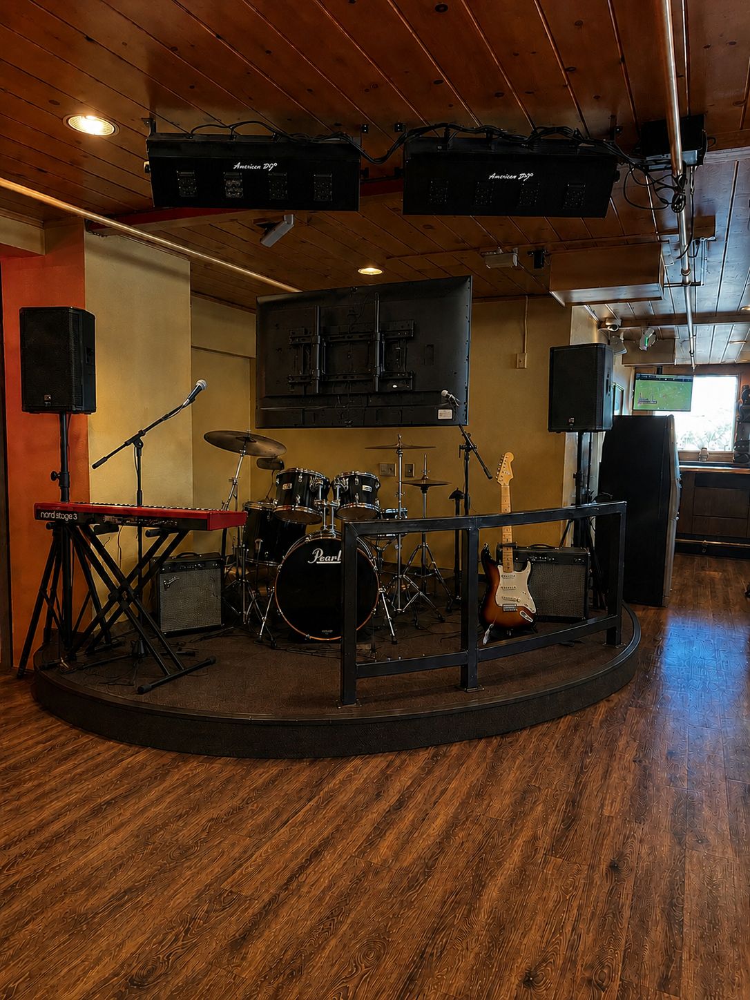 A music studio with a drum set, keyboard, and guitar.