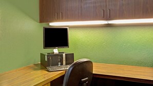 Un escritorio de madera con una computadora, que incluye un monitor, teclado y torre.