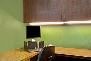 Un escritorio de madera con una computadora, que incluye un monitor, teclado y torre.