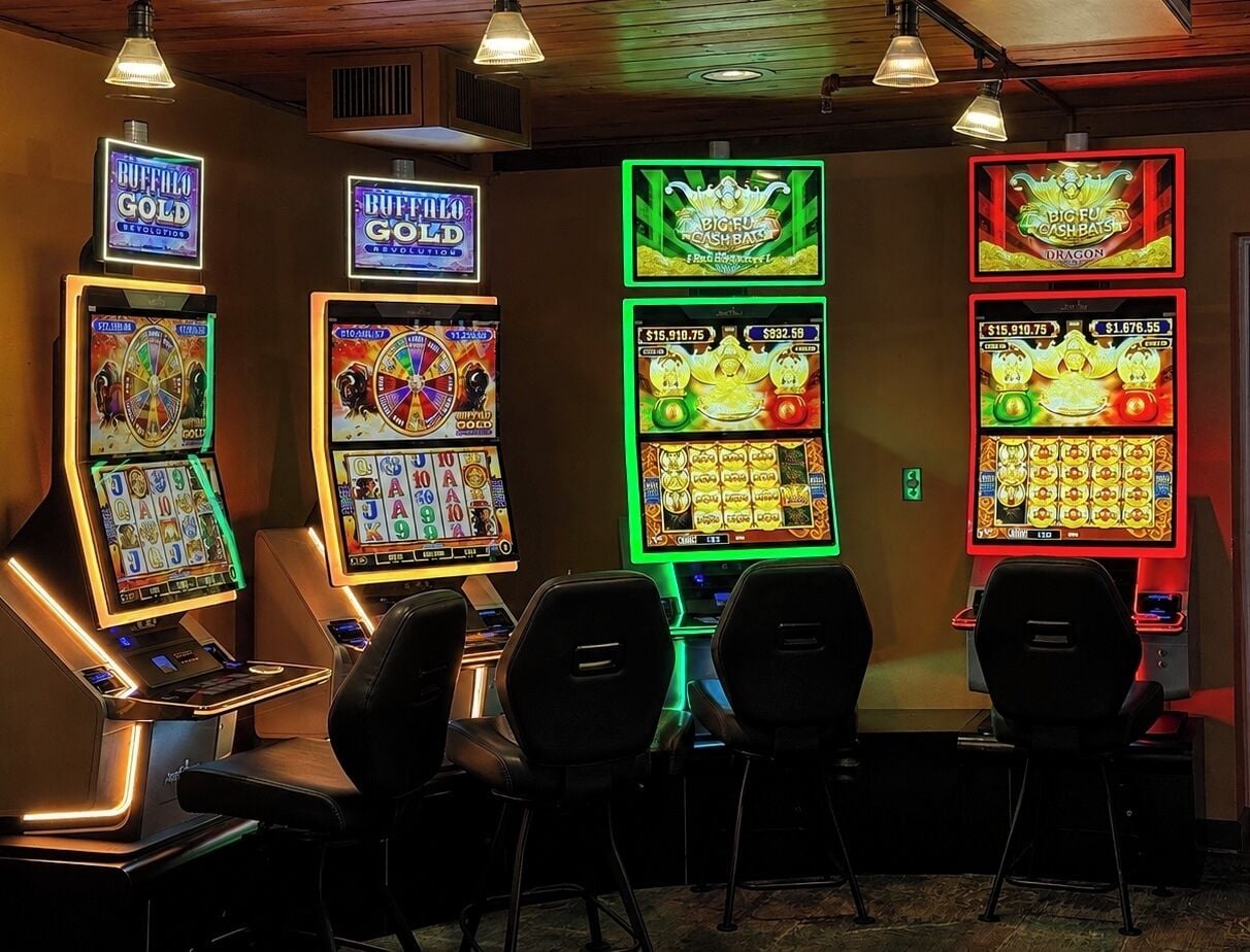 A row of slot machines with various game themes, including 'Buffalo Gold' and 'Big Fu Cash Bats.'