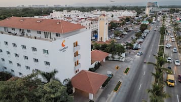 Un hotel Comfort Inn con tetto in tegole rosse, diversi piani e un parcheggio pieno di auto.