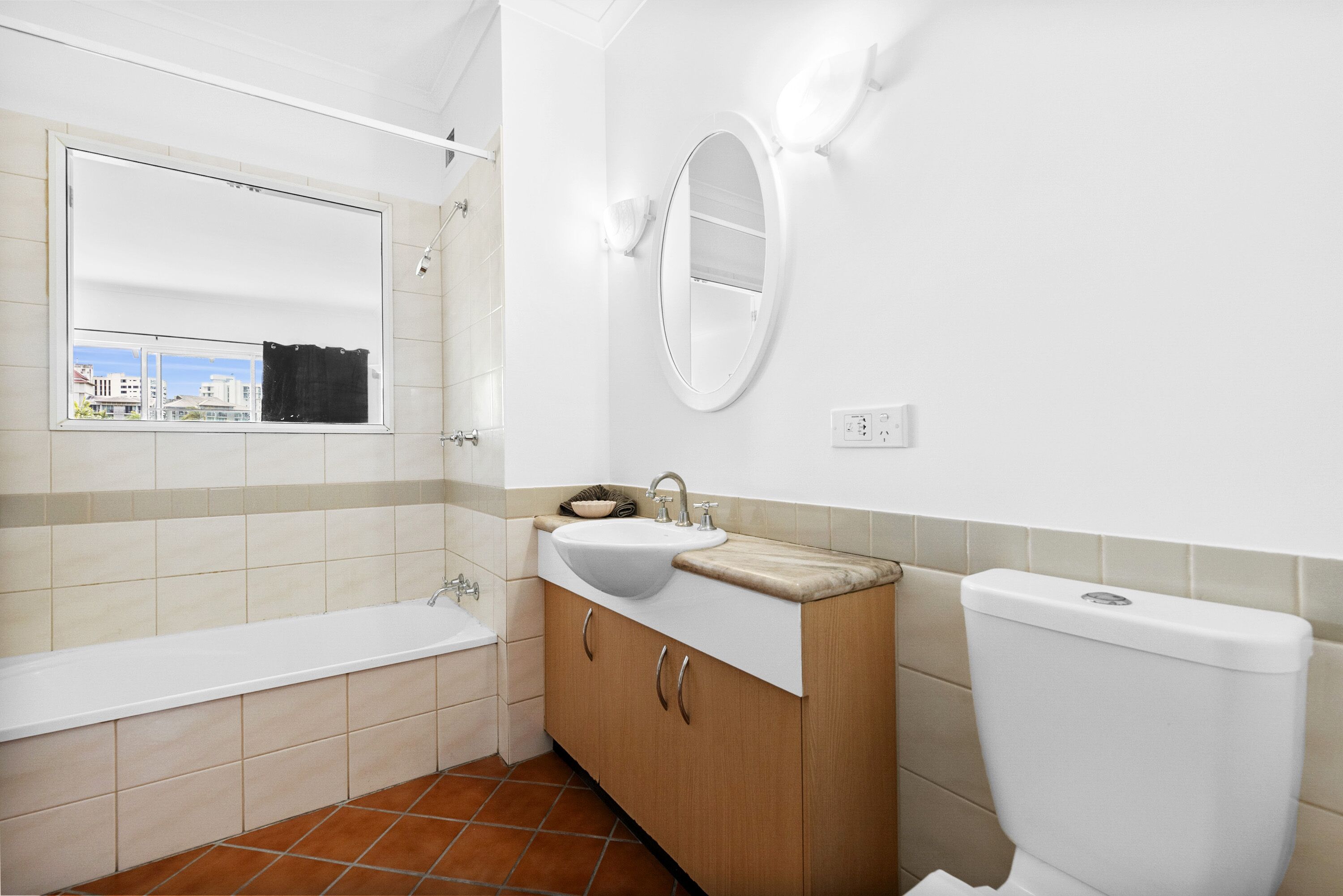 Et badeværelse med badekar, vask, spejl og toilet.