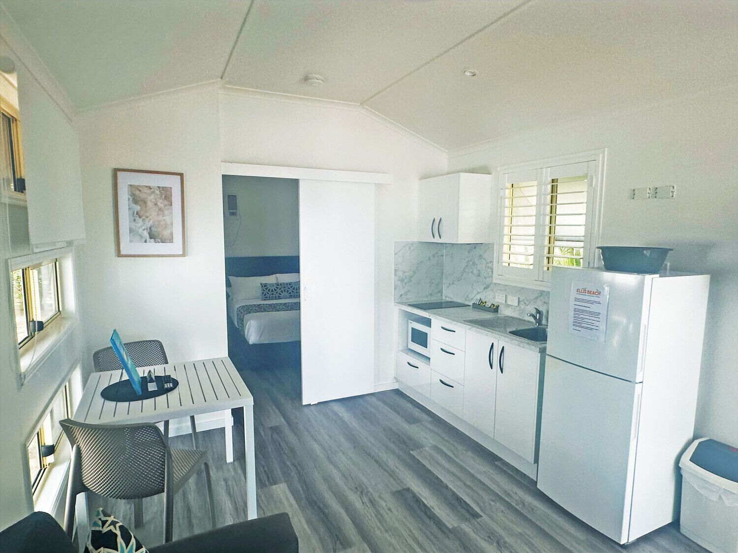 Habitación compacta con kitchenette, cama y pequeño comedor.