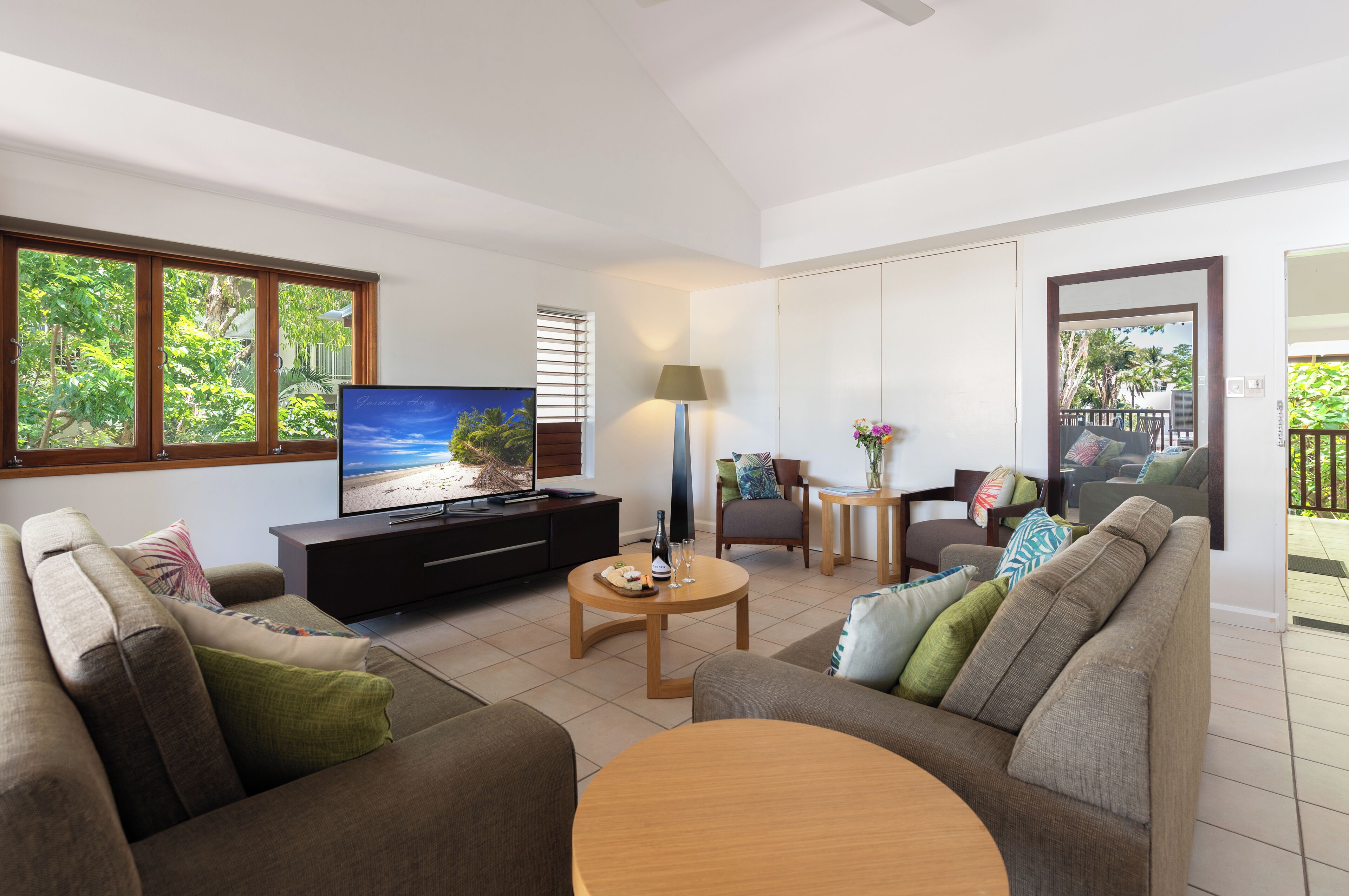 Una sala moderna con televisión de pantalla plana, un sofá, una mesa de centro y un comedor.