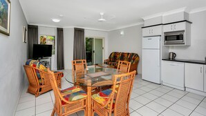 A modern kitchen with white cabinets, a microwave, and a dishwasher. - Beachfront Apartments on Trinity Beach (Trinity Beach)